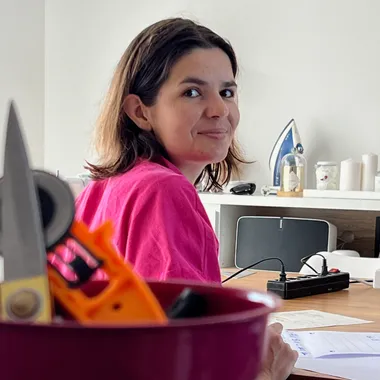 Nina, créatrice de l'Atelier Coeur Déjà Pris, souriante dans son atelier